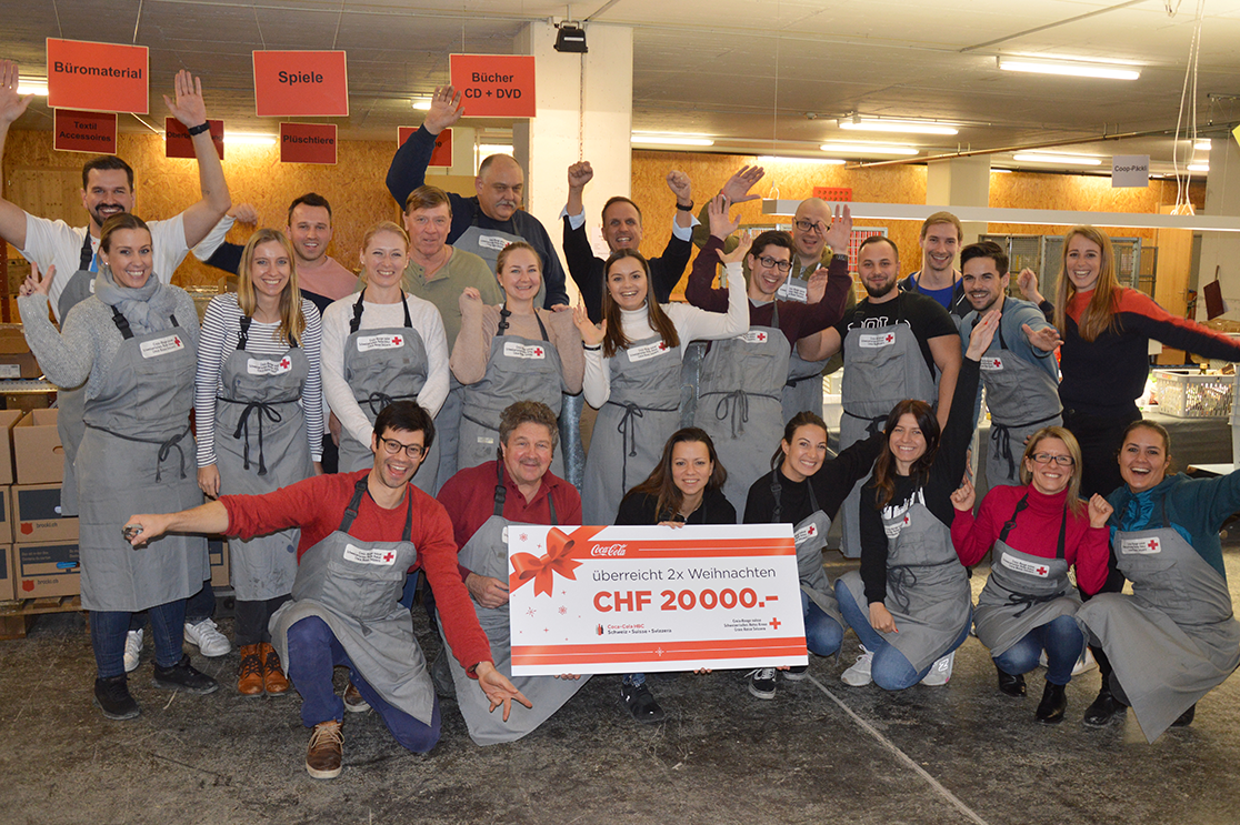 Check handover during the project. In addition to helping with packing, Coca‑Cola HBC Switzerland donates 20,000 Swiss francs for 2x Christmas, to cover the administrative costs of the project.