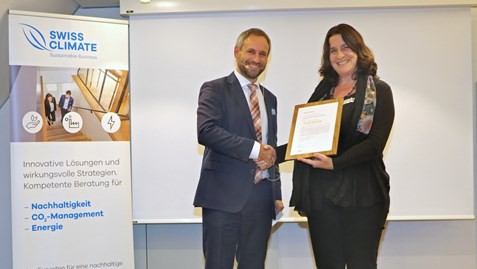 Monica Lehman, National Environment Manager, reçoit le certificat de la Swiss Climate des mains du CEO Mathias Bürgi.